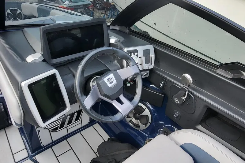 Slide: The Image of 2021 Malibu Wakesetter 23 MXZ dashboard with steering wheel and digital displays. - 12