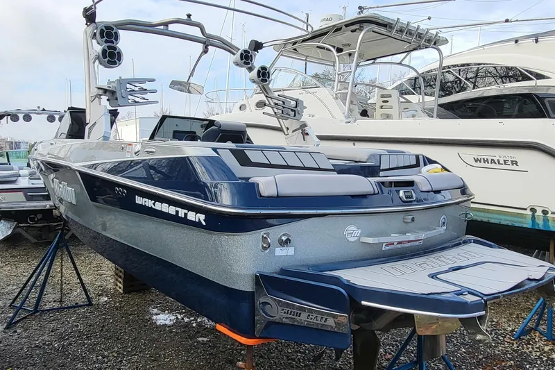 Slide: The Image of 2021 Malibu Wakesetter 23 MXZ boat on stands, surrounded by other vessels. - 6