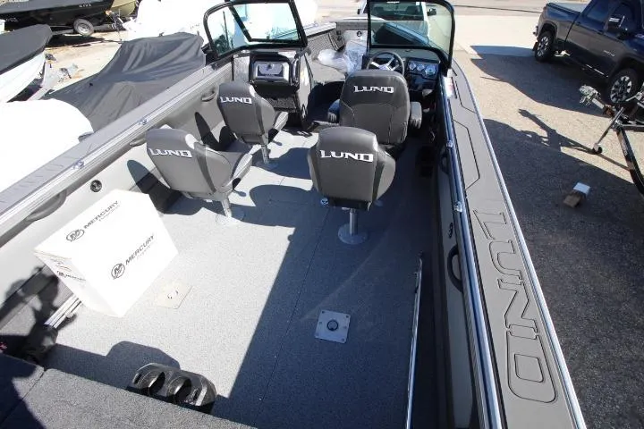 Slide: The Image of 2026 Lund 2275 Baron boat interior with four seats and Mercury box on deck. - 1