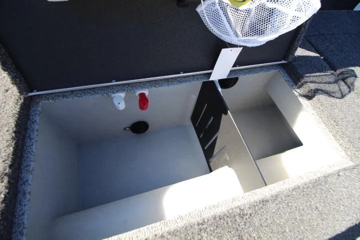 Slide: The Image of 2026 Lund 2275 Baron boat storage compartment with dividers and utility connections. - 16