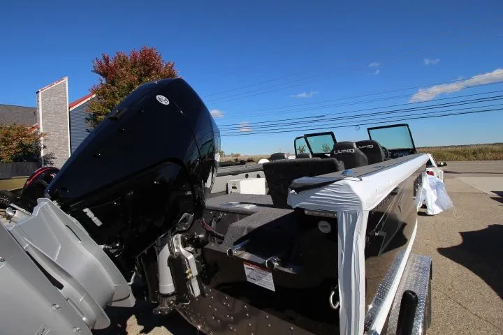 Slide: The Image of 2026 Lund 2275 Baron boat with powerful outboard motor on a sunny day. - 18