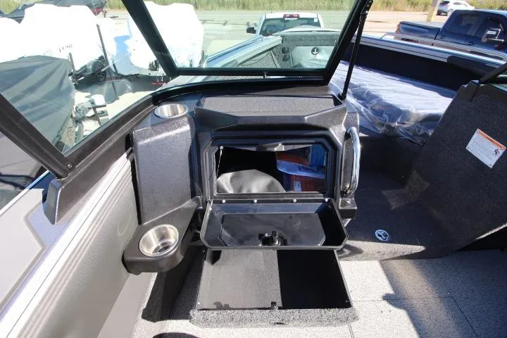 Slide: The Image of 2026 Lund 2275 Baron boat interior with open storage compartment and cup holders. - 5