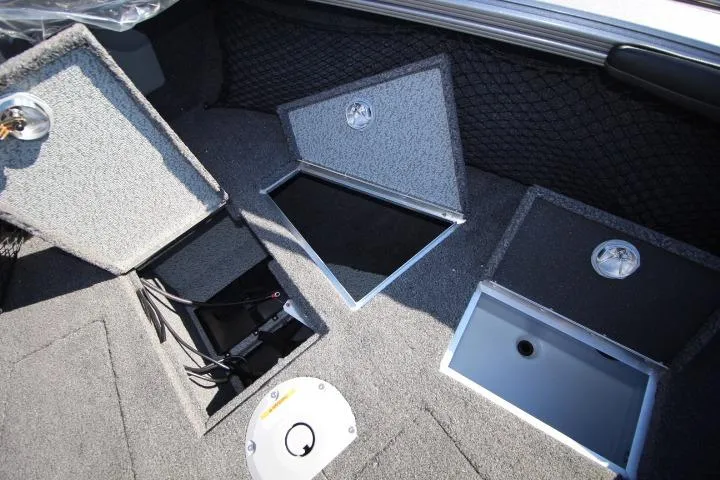 Slide: The Image of Interior storage compartments of 2026 Lund 2275 Baron boat, featuring carpeted finish and secure latches. - 9