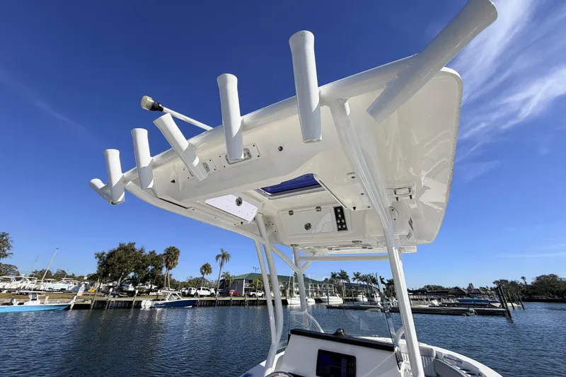 Slide: The Image of 2018 Sea Fox 248 Commander boat with rod holders, docked under clear blue sky. - 12