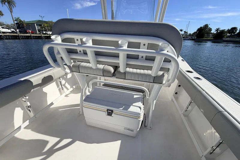 Slide: The Image of 2018 Sea Fox 248 Commander boat interior with seating and cooler, docked by the water. - 17