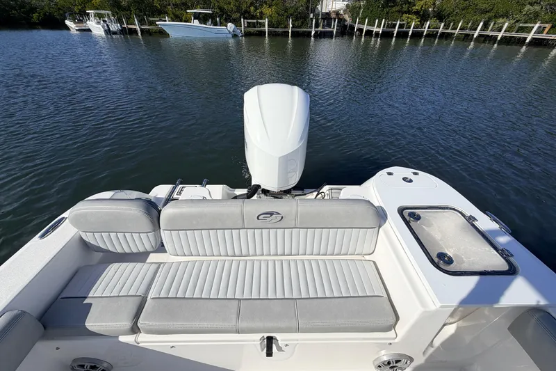 Slide: The Image of 2018 Sea Fox 248 Commander boat with cushioned seating and outboard motor on calm water. - 18