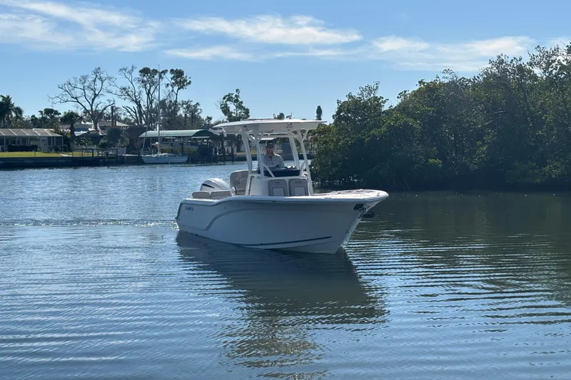 Slide: The Image of 2018 Sea Fox 248 Commander boat cruising on a calm river under a clear blue sky. - 2