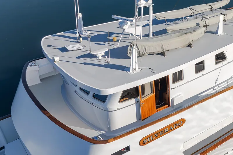 Slide: The Image of 1974 Willard 1201 yacht "Silverado" with sleek design and wooden accents on deck. - 12