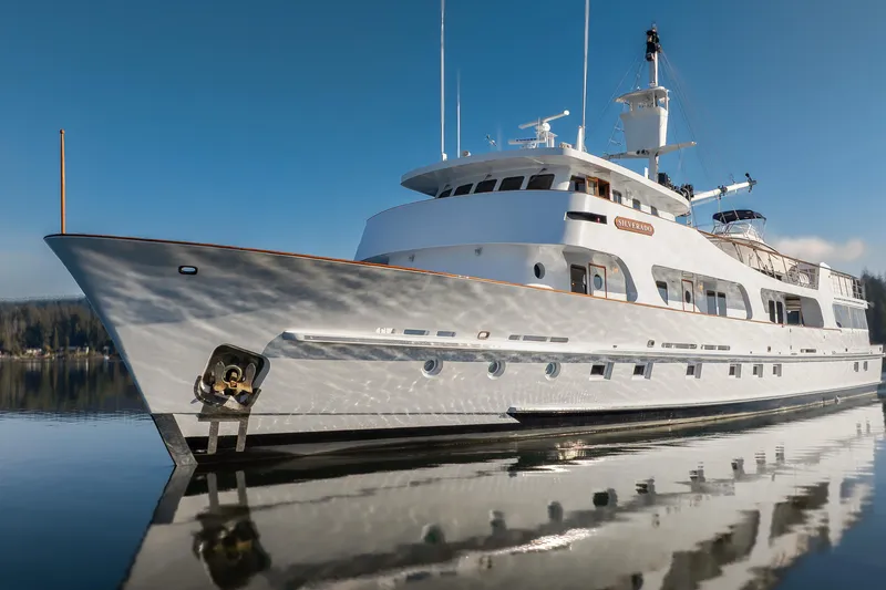 Slide: The Image of Luxurious 1974 Willard 1201 yacht reflecting on calm water under clear blue sky. - 14