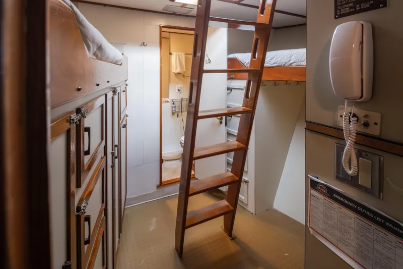 Slide: The Image of Interior of a 1974 Willard 1201 boat with bunk beds and a wooden ladder. - 36
