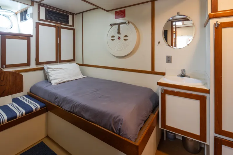 Slide: The Image of 1974 Willard 1201 boat cabin with bed, sink, and porthole window. - 37
