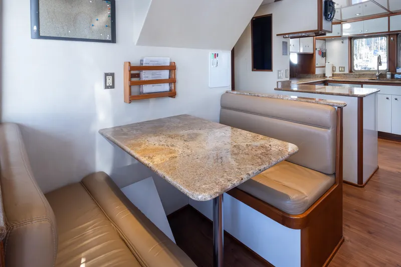 Slide: The Image of Cozy dining area in a 1974 Willard 1201 boat with beige seating and granite table. - 40