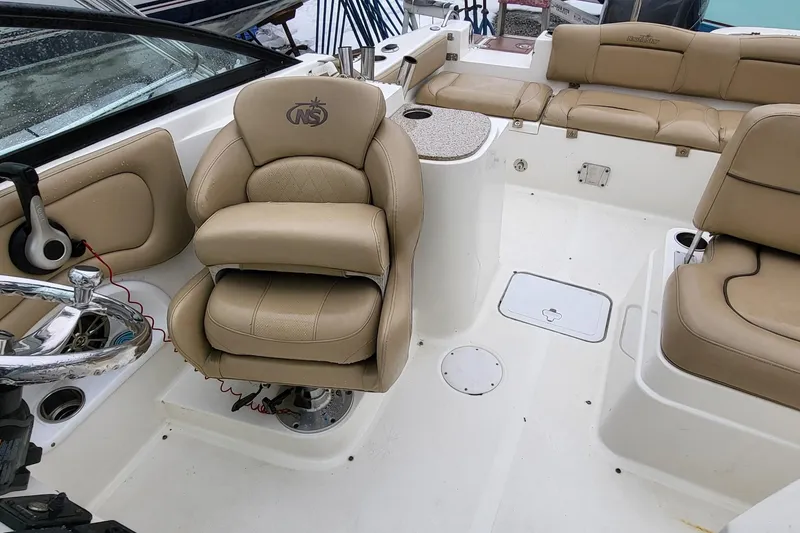 Slide: The Image of 2018 NauticStar 2302 Legacy boat interior with beige seating and steering wheel. - 10