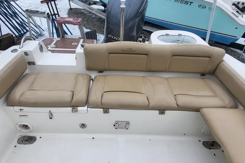 Slide: The Image of 2018 NauticStar 2302 Legacy boat interior with tan seating and storage compartments. - 12