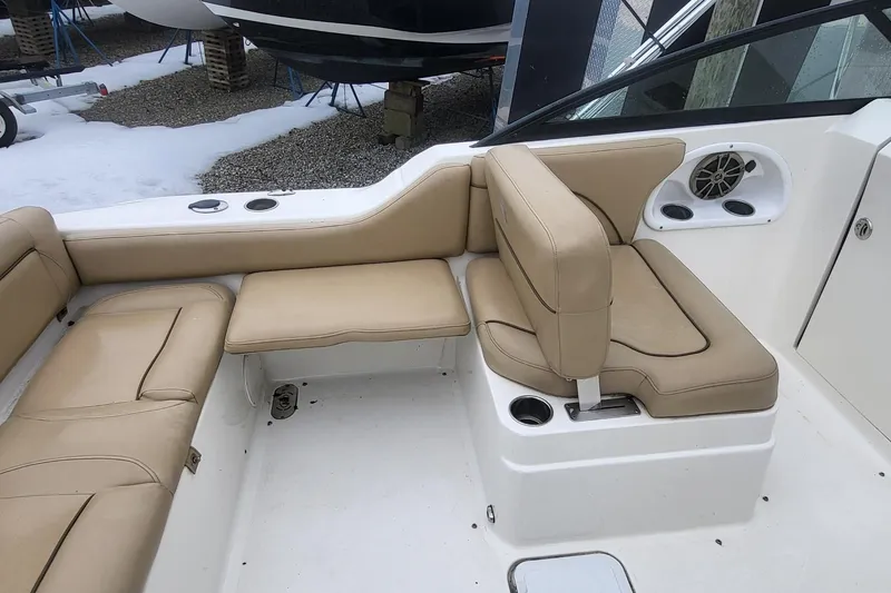 Slide: The Image of 2018 NauticStar 2302 Legacy boat interior with beige seating and cup holders. - 14