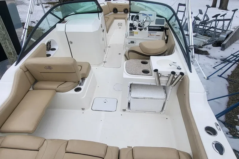 Slide: The Image of 2018 NauticStar 2302 Legacy boat interior with beige seating and fishing rod holders. - 15