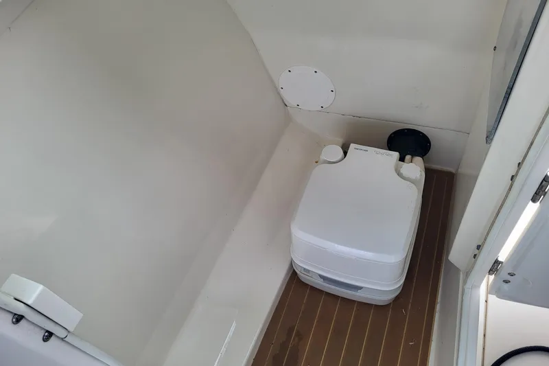 Slide: The Image of 2018 NauticStar 2302 Legacy boat interior with tan seating and dual windshields. - 8