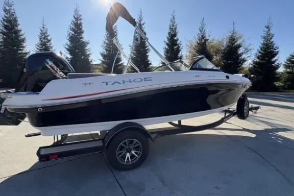Slide: The Image of 2022 Tahoe 200 S boat on trailer, parked outdoors with trees in background. - 4