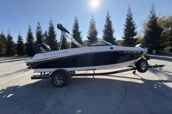 Slide: The Image of 2022 Tahoe 200 S boat on trailer, parked outdoors with trees in background. - 5