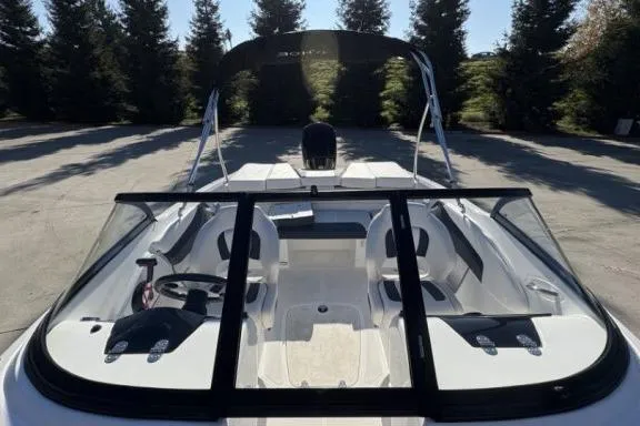 Slide: The Image of 2022 Tahoe 200 S boat with sleek interior and canopy, parked outdoors. - 9