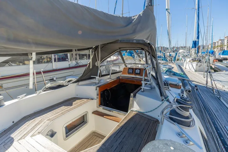 Slide: The Image of 1983 Baltic 42 DP sailboat cockpit with wooden deck and marina view. - 11