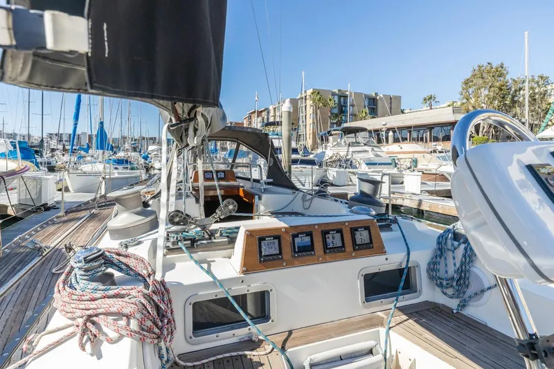 Slide: The Image of 1983 Baltic 42 DP sailboat docked in a marina, showcasing cockpit and navigation instruments. - 14