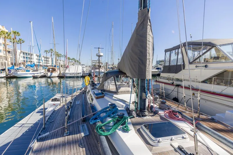 Slide: The Image of 1983 Baltic 42 DP sailboat docked in a sunny marina, surrounded by other boats. - 19