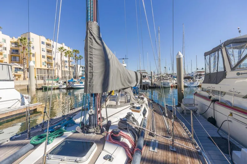 Slide: The Image of 1983 Baltic 42 DP sailboat docked in a sunny marina with surrounding yachts. - 21