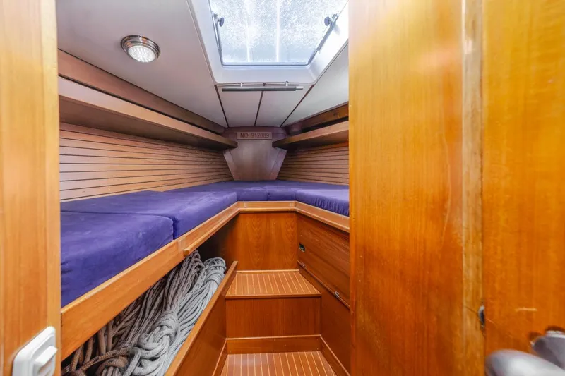 Slide: The Image of Cozy cabin interior of 1983 Baltic 42 DP sailboat with wooden finish and blue bedding. - 29