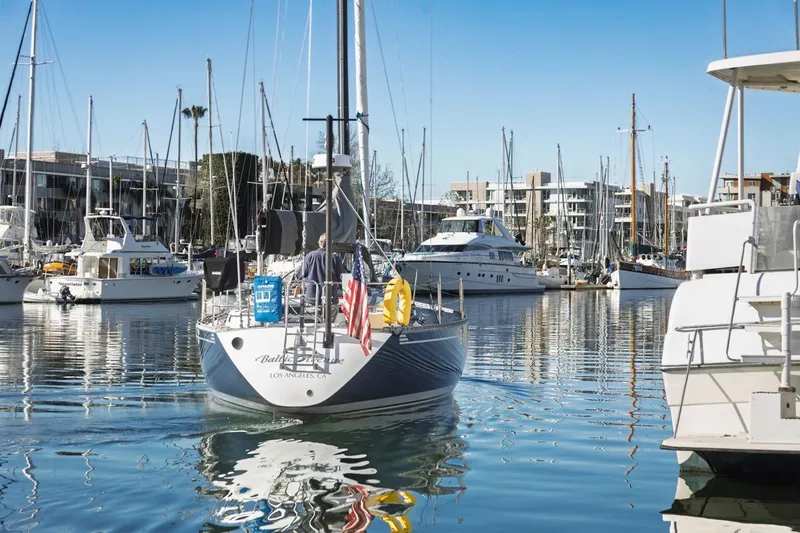 Slide: The Image of 1983 Baltic 42 DP sailboat in a marina, surrounded by other boats and clear blue sky. - 3