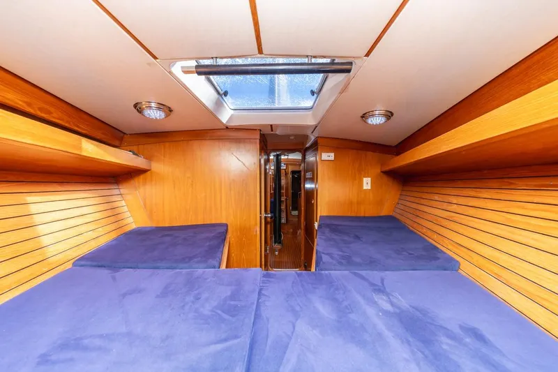 Slide: The Image of Interior cabin of 1983 Baltic 42 DP yacht with wooden paneling and blue cushions. - 30