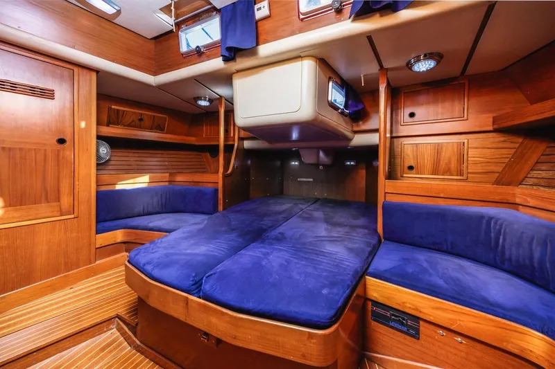 Slide: The Image of Luxurious 1983 Baltic 42 DP yacht interior with blue cushions and wooden finish. - 36