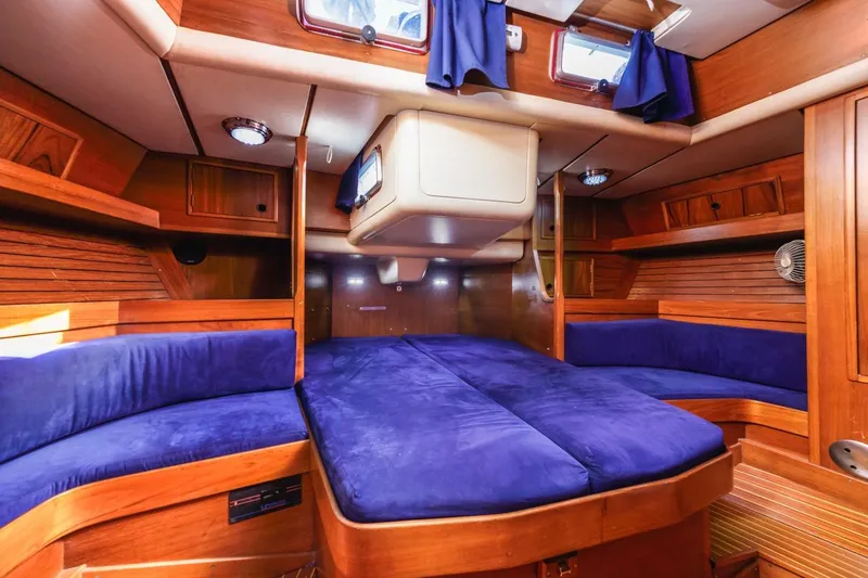 Slide: The Image of Luxurious 1983 Baltic 42 DP yacht interior with blue cushions and wooden finish. - 37