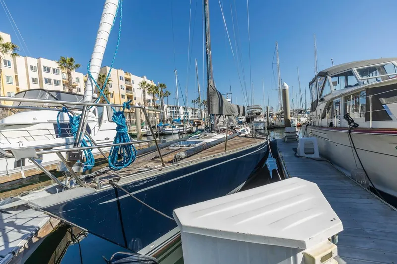 Slide: The Image of 1983 Baltic 42 DP sailboat docked in a marina, surrounded by other boats and buildings. - 6