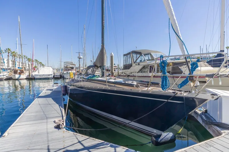 Slide: The Image of 1983 Baltic 42 DP sailboat docked in a sunny marina, surrounded by other boats. - 7