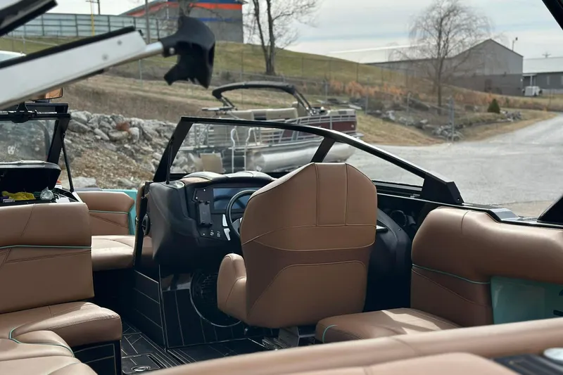 Slide: The Image of 2022 Centurion Fi23 boat interior with brown leather seats and modern dashboard. - 10