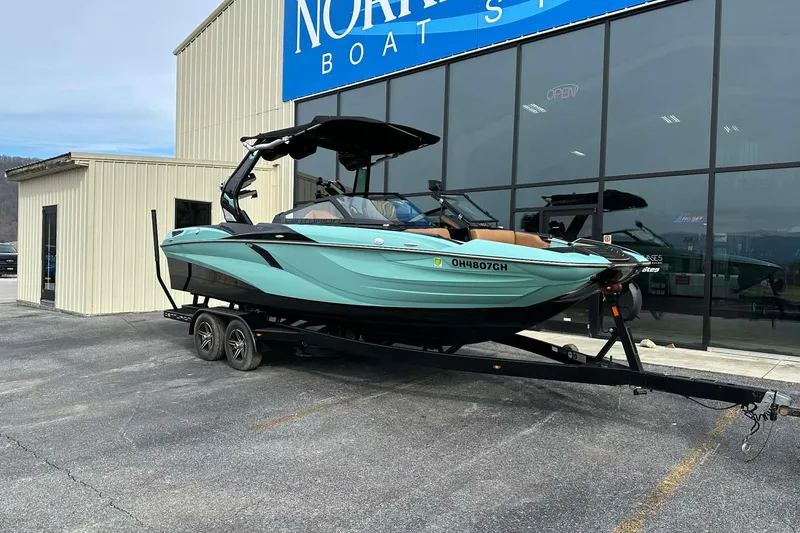 Slide: The Image of 2022 Centurion Fi23 boat on trailer outside dealership, showcasing sleek design and modern features. - 2