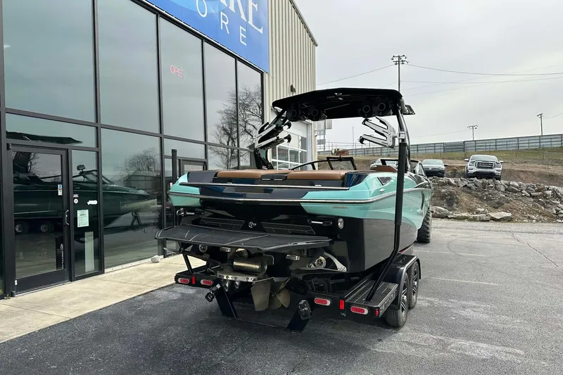 Slide: The Image of 2022 Centurion Fi23 boat on trailer outside a showroom, showcasing sleek design and modern features. - 3