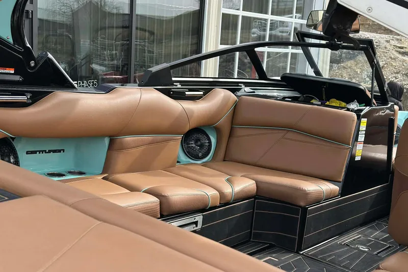 Slide: The Image of 2022 Centurion Fi23 boat interior with brown leather seating and teal accents. - 8