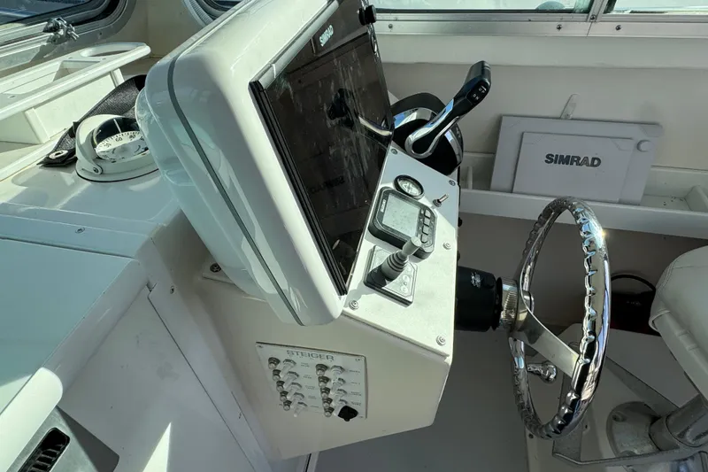 Slide: The Image of 2008 Steiger Craft 23 Miami boat helm with Simrad navigation system and steering wheel. - 12