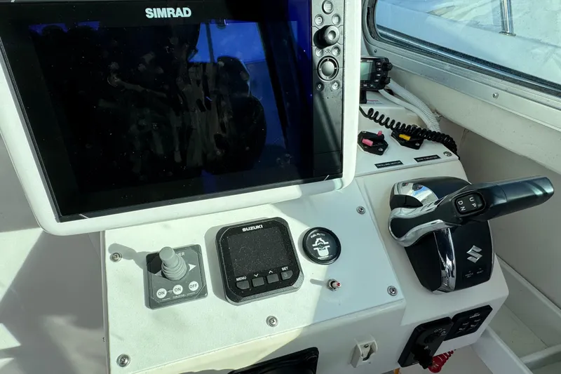 Slide: The Image of 2008 Steiger Craft 23 Miami boat dashboard with Simrad display and Suzuki controls. - 8
