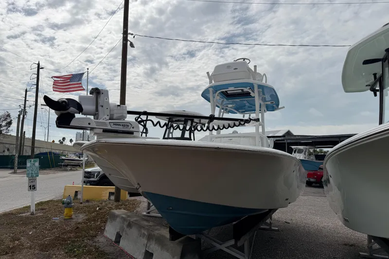 Slide: The Image of 2026 Tidewater 2500 Carolina Bay boat with Minn Kota motor, parked outdoors. - 1