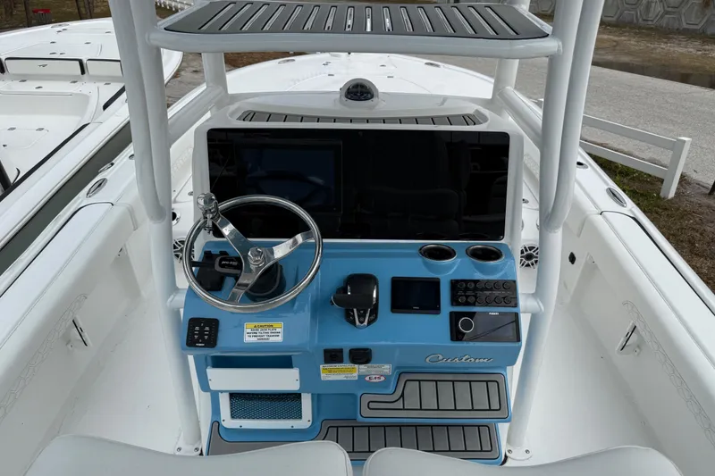 Slide: The Image of 2026 Tidewater 2500 Carolina Bay boat console with steering wheel and controls. - 10