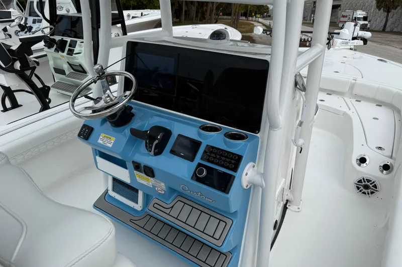 Slide: The Image of 2026 Tidewater 2500 Carolina Bay boat console with steering wheel and electronic controls. - 11