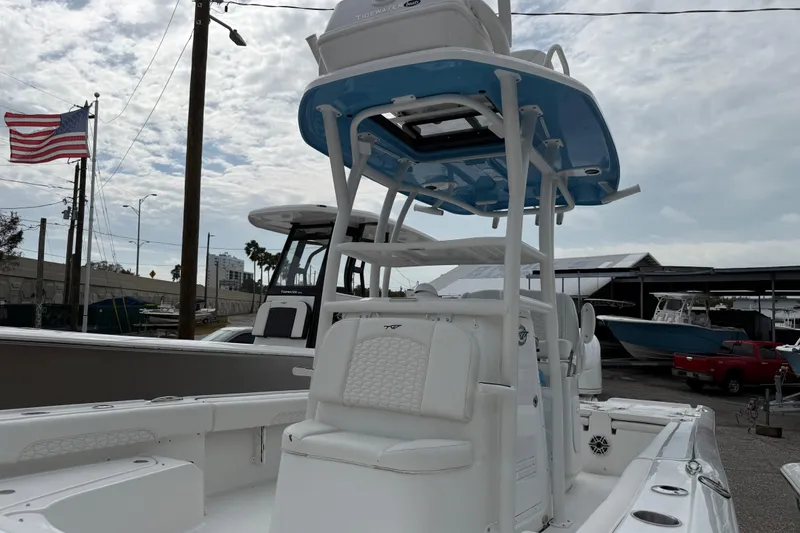 Slide: The Image of 2026 Tidewater 2500 Carolina Bay boat with T-top, docked near American flag. - 4