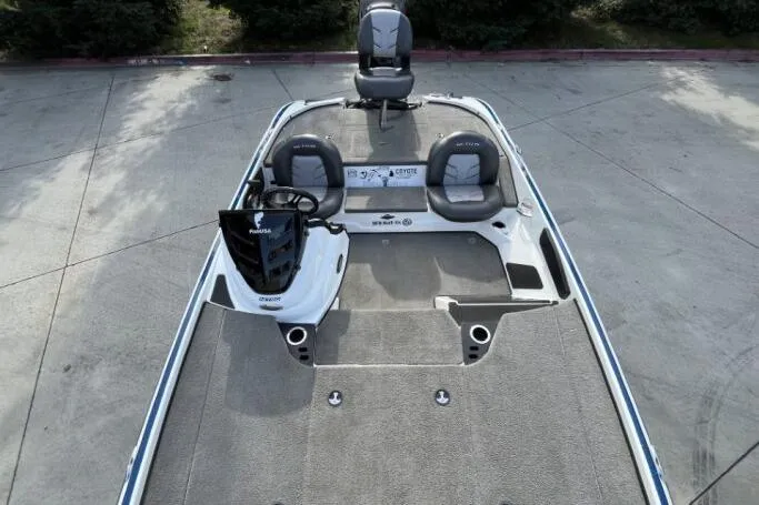 Slide: The Image of 2016 Nitro Z18 boat interior with seating and steering console, parked on concrete. - 10