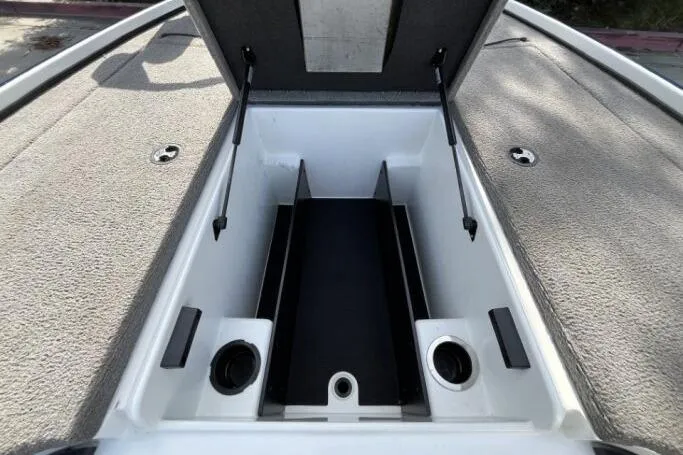 Slide: The Image of Open storage compartment of 2016 Nitro Z18 boat, featuring carpeted interior and hydraulic supports. - 11