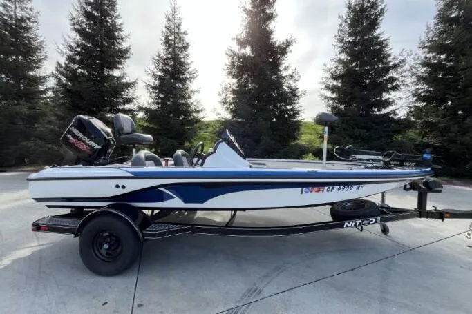 Slide: The Image of 2016 Nitro Z18 boat on trailer, parked outdoors with trees in background. - 4
