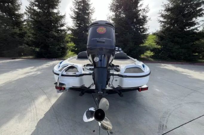 Slide: The Image of 2016 Nitro Z18 boat with outboard motor, parked on concrete, surrounded by trees. - 5