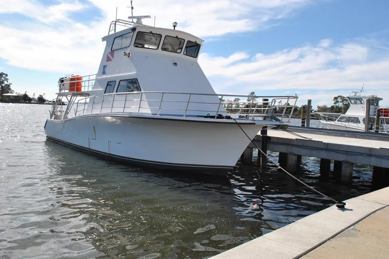 The Image of 2019 Newton 53 dive boat docked at a marina under a clear sky. - 1
